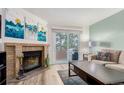 Cozy living room with a brick fireplace, sliding glass door to backyard, and modern decor at 11147 W 17Th Ave # 103, Lakewood, CO 80215