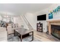 Spacious living room featuring a fireplace, TV, staircase, and open floor plan at 11147 W 17Th Ave # 103, Lakewood, CO 80215