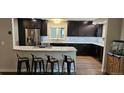 This bright kitchen features updated appliances, granite countertops, barstool seating, and sleek wood flooring at 11355 Haswell Dr, Parker, CO 80134