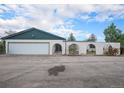 Exterior view of house showing a two car garage and arched privacy fence at 15623 Degaulle Cir, Brighton, CO 80603