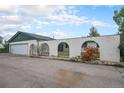 Exterior view of home showing garage and fence with arches, with landscaping at 15623 Degaulle Cir, Brighton, CO 80603