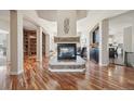 Inviting living room with a stone fireplace, gleaming hardwood floors, and abundant natural light at 7081 Salvia St, Arvada, CO 80007