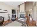 Cozy living room with a stone fireplace, gleaming hardwood floors, wet bar, and abundant natural light at 7081 Salvia St, Arvada, CO 80007
