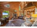 Cozy living room featuring a stone fireplace, hardwood floors, and vaulted ceilings at 80 Spruce Ct, Evergreen, CO 80439
