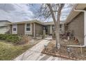 Inviting walkway leads to the front door of this brick home, complemented by garden accents and mature landscaping at 8150 W Calhoun Dr, Littleton, CO 80123