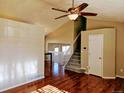 Open-concept living room featuring hardwood floors, a staircase, and plenty of natural light from adjacent rooms at 4395 S Gibraltar St, Centennial, CO 80015