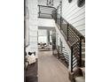 Open entryway featuring a wooden staircase with black railings, hardwood flooring, and natural light at 5726 Margarita Pt, Parker, CO 80134