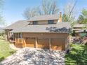 An attractive brick house with a three-car garage, a covered porch, and a well-manicured lawn at 128 Baylor Dr, Longmont, CO 80503