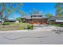 Charming home featuring a three-car garage and a lush green lawn with mature trees at 128 Baylor Dr, Longmont, CO 80503