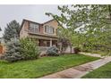 Inviting two-story home with a charming front porch and lush greenery, perfect for enjoying peaceful surroundings at 176 S Rosemary St, Denver, CO 80230
