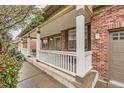 Charming front porch featuring white railings, brick accents, and cozy seating, ideal for relaxing outdoors at 176 S Rosemary St, Denver, CO 80230
