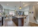 Open-concept kitchen with a large granite island, pendant lighting, and views into the dining and living areas at 1158 Sugarloaf Ln, Erie, CO 80516