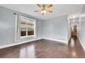 Bright living room featuring hardwood floors, a ceiling fan, large window, and neutral-colored walls at 3612 Hudson St, Denver, CO 80207