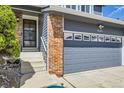Close-up of the home's entrance, highlighting the brick and siding detail and attached two-car garage at 3680 S Gibralter Cir, Aurora, CO 80013