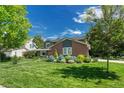 Charming two-story brick home with a beautiful lawn and manicured landscaping at 10289 E Berry Dr, Greenwood Village, CO 80111