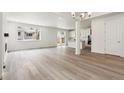 Open-concept living room with hardwood floors and a modern chandelier at 9266 Telluride Ct, Commerce City, CO 80022