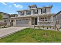 Inviting two-story home featuring a brick-accented garage, covered porch, and manicured lawn at 7325 S Waterloo Way, Aurora, CO 80016