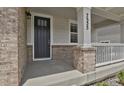 Close-up view of the front door with stylish brick accents and a covered porch at 7325 S Waterloo Way, Aurora, CO 80016