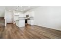 Bright kitchen with white cabinets, granite countertops, stainless steel appliances, and wood floors at 18712 E 99Th Ave, Commerce City, CO 80022