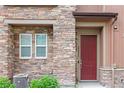 Close up of the front door showing brick accents, a window and a red door at 2225 Santini Trl # C, Littleton, CO 80129