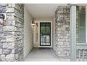 Close-up of the front entrance, with stonework, a secure door, and stylish outdoor lighting at 8773 S Dudley St, Littleton, CO 80128