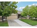 Charming exterior view of the home with mature trees, a long driveway, and a two-car garage at 8773 S Dudley St, Littleton, CO 80128