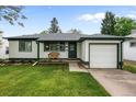 Inviting home featuring a well-kept lawn, dark green trim, and front bench, exuding classic charm at 3231 S Elati St, Englewood, CO 80110