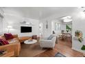 Bright living room featuring hardwood floors, modern decor, and an open flow to dining area at 3231 S Elati St, Englewood, CO 80110