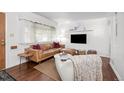 Cozy living room with hardwood floors, leather sofa, textured rug, and lots of natural light at 3231 S Elati St, Englewood, CO 80110