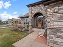 Inviting entryway featuring stone detailing, a decorative bench, and a stylish front door at 11910 W 83Rd Pl, Arvada, CO 80005