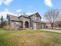 Beautiful home with stone accents, manicured lawn, and a welcoming front entrance at 11910 W 83Rd Pl, Arvada, CO 80005
