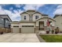 Two-story home with three-car garage, stone accents, landscaped front yard, and an American flag at 11657 Olathe St, Commerce City, CO 80022