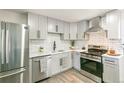 Beautiful kitchen features stainless steel appliances, light grey cabinets, and a white subway tile backsplash at 315 S Xapary St, Aurora, CO 80012