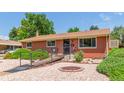 Single story brick home featuring accessible ramp, gravel landscaping, and mature bushes at 3225 W Mexico Ave, Denver, CO 80219