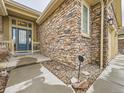 Attractive front entrance with stone veneer, stylish blue door and manicured landscaping at 424 N De Gaulle Ct, Aurora, CO 80018