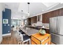 Modern kitchen with dark wood cabinets, stainless steel appliances, and a large island at 903 E 13Th Ave, Denver, CO 80218