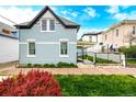 The exterior side of a beautiful light-blue two-story house is enhanced by a well-maintained lawn and lush landscaping at 1019 26Th St, Denver, CO 80205