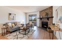 Comfortable living room featuring a stone fireplace, balcony access, and modern furnishings at 8335 Fairmount Dr # 7-208, Denver, CO 80247