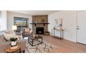 Bright living room features a stone fireplace, hardwood floors, and modern furniture at 8335 Fairmount Dr # 7-208, Denver, CO 80247