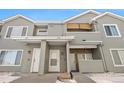 Townhome exterior with gray siding and stone accents with a shared covered entryway with unit numbers and white doors at 912 S Yampa St # 208, Aurora, CO 80017