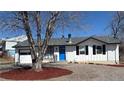 Charming brick home with a blue front door, and landscaping at 7604 Reed St, Arvada, CO 80003