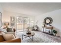 Bright living room featuring a sliding glass door, stylish furniture, and elegant decor at 10211 Ura Ln # 7-204, Thornton, CO 80260