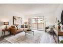 Relaxing living room offering a sliding glass door, comfortable seating, and charming accents at 10211 Ura Ln # 7-204, Thornton, CO 80260
