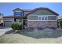 Inviting two-story home with a three car garage, stone accents, and well-manicured landscaping at 11918 S Hitching Post Trl, Parker, CO 80134