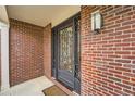 Elegant front door with intricate wrought iron detailing, set against a classic brick facade at 18225 E Caley Dr, Aurora, CO 80016