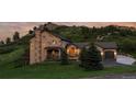 Charming stucco home with stone accents, a three-car garage, and mature landscaping at 6402 Wauconda Dr, Larkspur, CO 80118