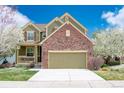 Inviting two-story home featuring a brick facade, covered porch, and well-maintained lawn at 6378 Noble Ct, Arvada, CO 80403