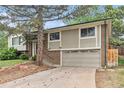 Home featuring a two-car garage, brick and siding, with mature trees at 2743 S Reading Ct, Denver, CO 80231