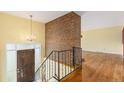 Inviting foyer with hardwood floors, brick wall, and elegant chandelier at 2743 S Reading Ct, Denver, CO 80231