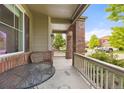 Charming covered front porch with seating area and brick pillars at 41 Jordan Ln, Erie, CO 80516